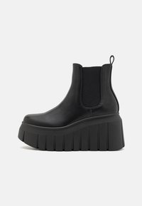 Stivali Chelsea neri con platform, realizzati in pelle liscia, dotati di pannelli laterali elasticizzati e suola a gola ribattuta. Presentano un manico sul retro.
