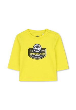 Geel katoen lange mouwen shirt met een ronde halslijn en een grafisch logo in het zwart. Drukknopen aan de linkerschouder.