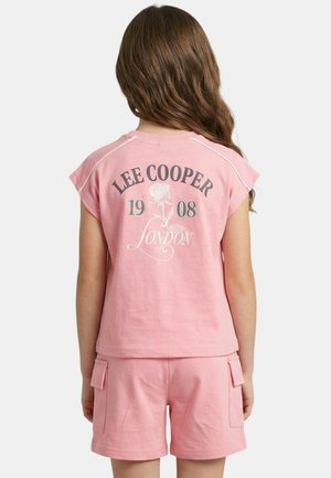 Enfant portant un tee-shirt rose Lee Cooper et un short assorti, de dos, avec un texte et un motif de rose au dos du tee-shirt.