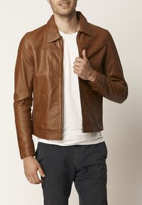 Braune Lederjacke mit einem frontalen Reißverschluss, Spitzkragen und seitlichen Taschen. Glatte Textur mit subtilen Nähdetails und tailliertem Design.