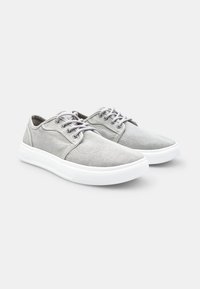 Sneakers in tela grigia con design a basse top, caratterizzati da suole in gomma bianca e lacci abbinati. Parte superiore testurizzata e silhouette slanciata.