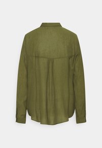 Chemise vert olive à manches longues avec empiècement droit dans le dos et poignets boutonnés, vue de dos sur un fond blanc uni.