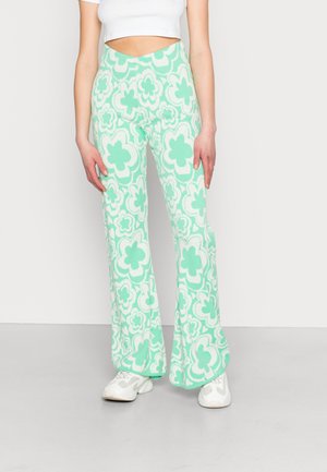 Calças flare em verde menta com um padrão floral. Feitas de um tecido suave e texturizado. Apresentam uma cintura alta e pernas largas.
