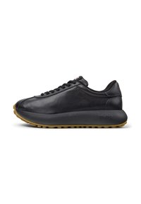 Black leather sneakers with a smooth texture, rounded toe, and a thick rubber sole. Features sleek design and subtle branding on the side.