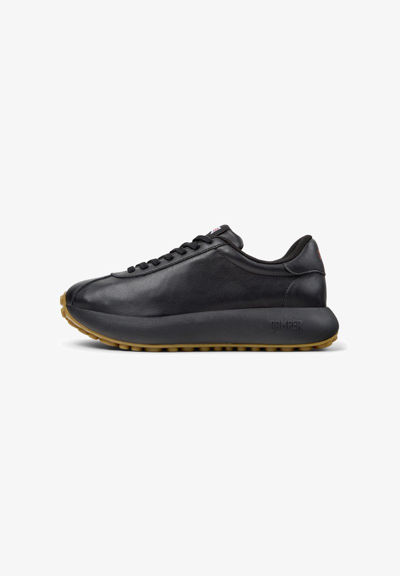 Black leather sneakers with a smooth texture, rounded toe, and a thick rubber sole. Features sleek design and subtle branding on the side.