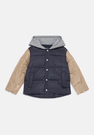 Chaqueta acolchada con un cuerpo azul marino oscuro, mangas beige y una capucha gris. Presenta botones a presión y dos bolsillos frontales. Textura suave y acolchada.