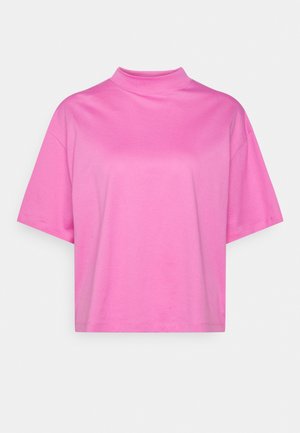 Roze T-shirt met korte mouwen, losse pasvorm en een hoge ronde hals, gefotografeerd tegen een neutrale achtergrond.