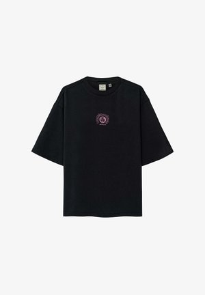 Czarny t-shirt z krótkim rękawem z małą różową grafiką słońca i księżyca na środku klatki piersiowej.