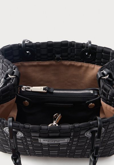 Μαύρη υφαντή τσάντα ώμου με μπεζ υφασμάτινη εσωτερική επένδυση, που διαθέτει μια μαύρη θήκη με φερμουάρ και ασημένιο μεταλλικό κούμπωμα στο εσωτερικό.