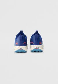 Baskets de sport bleues en matériaux en mesh et synthétiques. Semelle intermédiaire blanche mouchetée et semelle extérieure bleue. Accents rouges au niveau du talon et des côtés.