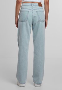 Svijetloplavi traper ankle jeans sa širokim nogavicama i visokim strukom, sa dva stražnja džepa, suptilnim prošivenim detaljima i smešnom kožnom oznakom na pojasu.
