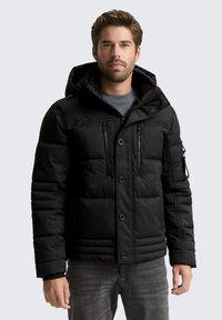 Černá péřová bunda s kapucí, vybavená zipem vpředu, dvěma kapsami na hrudi a žebrovanými manžetami. Hladký povrch, prošívaný vzor a střední délka.