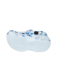 White shoe sole with blue and black graphic pattern, featuring raised traction elements and a circular black button near the instep.