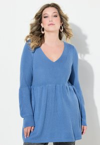 Blauer Strickpullover mit V-Ausschnitt, langen Ärmeln und einem Peplum-Design. Die Textur ist gerippt und bietet eine bequeme, lockere Passform.