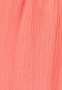 Tessuto leggero e stropicciato di colore corallo, con pieghe verticali e una consistenza liscia. Ideale per abbigliamento o accessori.
