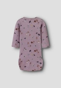 Combinaison bébé à manches longues lavande avec des imprimés de petits champignons, fleurs et feuilles dispersés dans des tons de violet doux, marron et blanc.