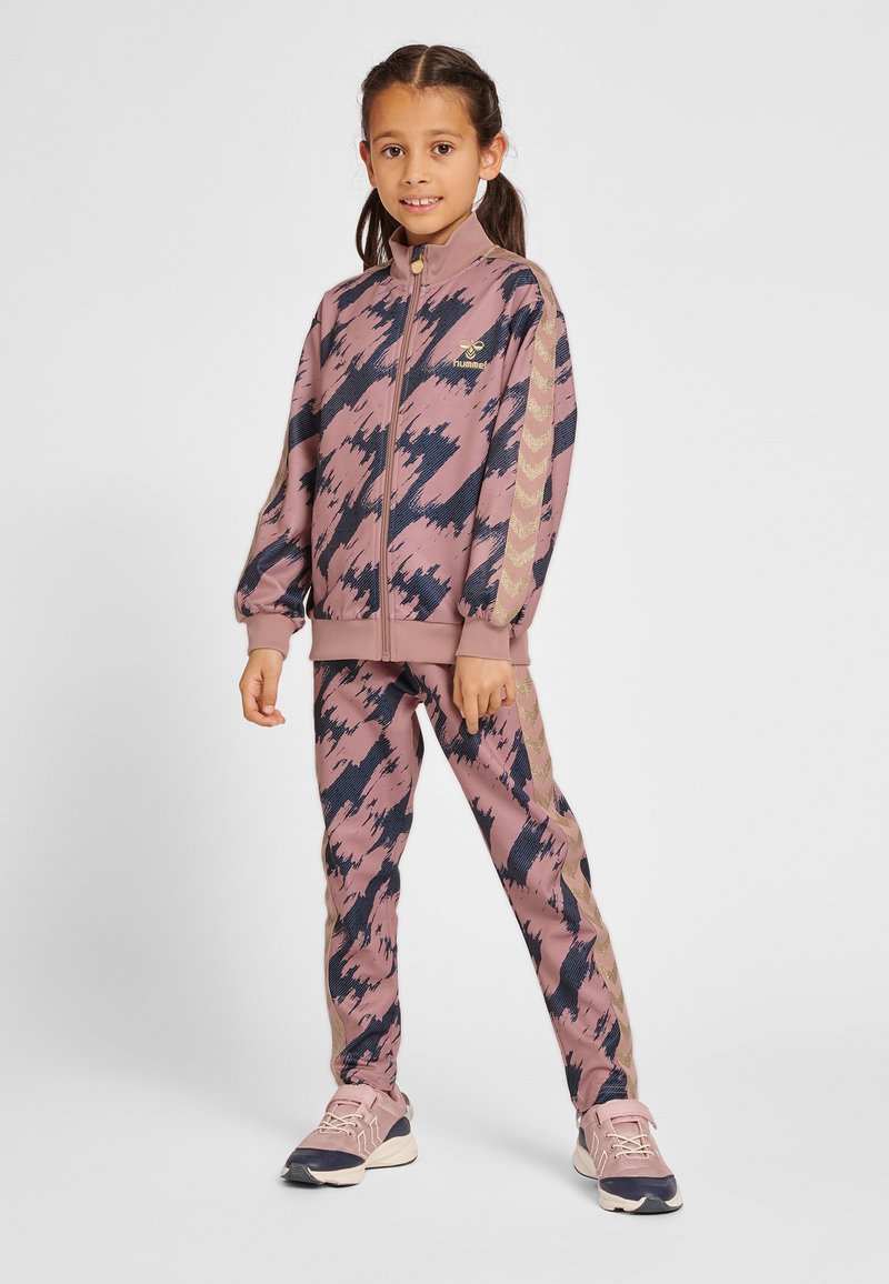 Rosa och marinblå atletisk träningsdräkt med abstrakt mönster, bestående av en jacka med dragkedja och matchande byxor, prydd med guldiga ränder längs ärmar och sidor.