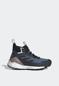 Scarpa da trekking di media altezza con tomaia blu scuro e nera, materiale Gore-Tex, accenti verde chiaro e una suola robusta bianca e grigia.