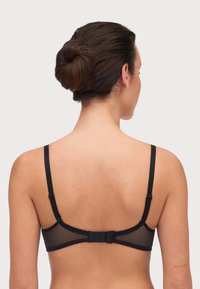 Sostenedor negro con espalda de malla texturizada, tirantes ajustables y cierre de gancho y ojo. Presenta un diseño minimalista y una tela suave.