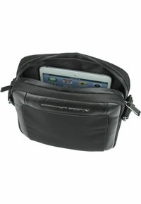 Borsa a tracolla nera con esterno testurizzato, interno imbottito e chiusura con zip, con un iPad visibile all'interno.