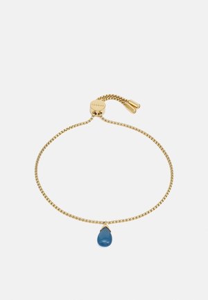 Bracelet chaîne ajustable en or avec un pendentif en pierre bleue en forme de goutte et des extrémités cylindriques.