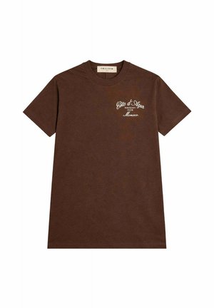 T-shirt marron à manches courtes avec col rond et inscription blanche "Côte d'Azur Racquet Club Monaco" sur la poitrine gauche.