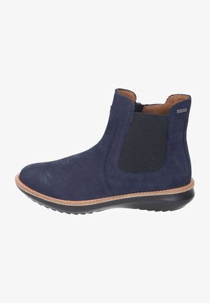 Bottine bleu marine avec panneau latéral élastique noir, couture beige, doublure intérieure marron et semelle en caoutchouc noire.