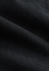 Tessuto nero con una texture liscia, caratterizzato da fibre strettamente intrecciate in un motivo diagonale. Finitura morbida e opaca senza accenti visibili.