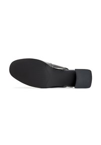 Zapato negro sin cordones con una parte superior suave y brillante y una suela de goma texturizada y plana. Presenta una puntera cuadrada y un detalle de costura mínima.