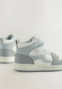 Pantofi sport înalți din piele gri și albă cu o textură netedă, având un guler căptușit și o talpă din cauciuc. Accentele includ cusături tonale.