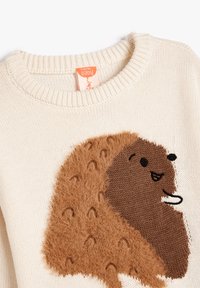 Sweter robiony na drutach w kolorze kremowym, z pluszowym wzorem jeża w kolorze brązowym, posiadającym haftowane oczy i buzię oraz fakturowane akcenty na ciele.