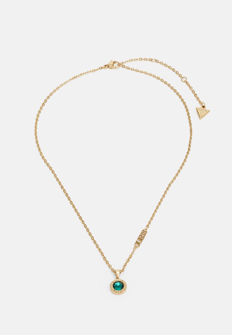 Collier en or avec un pendentif en pierre précieuse de couleur émeraude, entouré d'une bordure texturée et d'une étiquette de logo. Longueur ajustable pour un bon ajustement.