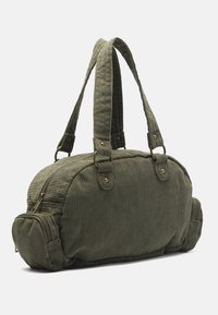 Grønne kordfløjs taske med rund form, dobbelt håndtag og messing hardware; har et lynlås hovedrum og en lille sidelomme.