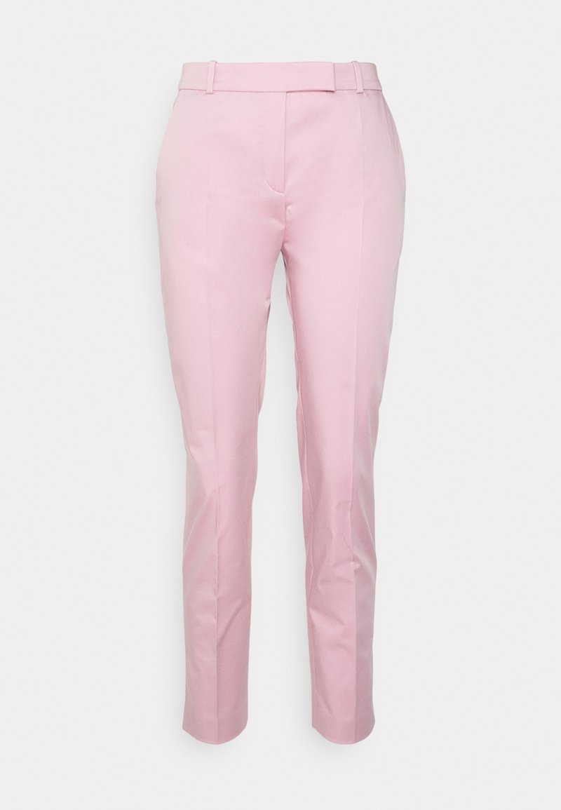 Pantalon rose clair sur mesure avec passants de ceinture, pli devant et coupe slim sur fond blanc uni.