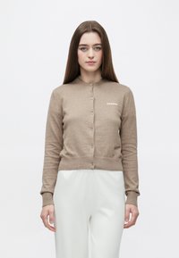 Jasnobrązowy kardigan z okrągłym dekoltem i zapięciem na guziki, wyposażony w ściągacze na rękawach i dole. Na piersi wyhaftowane logo "2ND DAY".