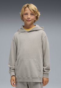 Felpa grigia chiara con tasca frontale, cappuccio con stringa e sottili dettagli grafici verdi. Tessuto morbido con vestibilità comoda e polsini a coste.