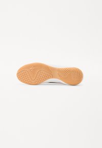 Suola di sneaker in gomma con un motivo texturizzato arancione, dotata di una parte superiore bianca e del logo del marchio incorporato nel design.