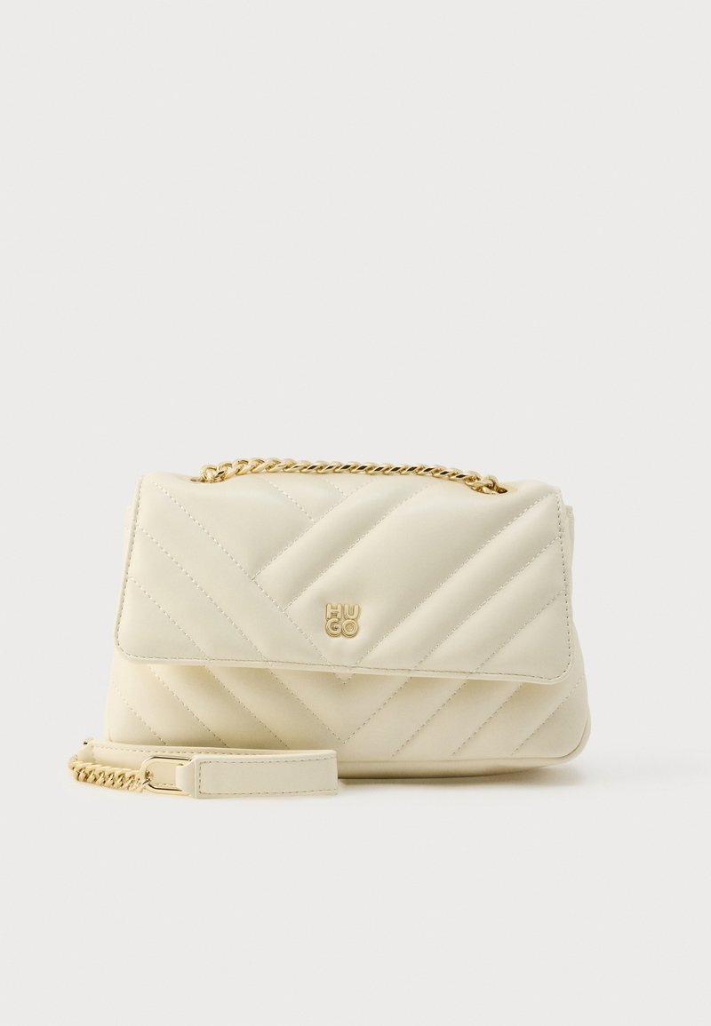 Kootud kreemjas käekott kuldse kettidega rihma ja logoga. Omab klapi sulgemist, siledat tekstuuri ja diagonaalset õmblusmustrit.