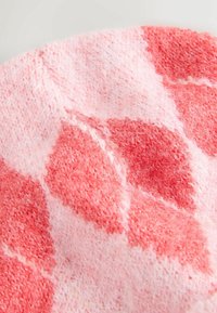 Strickdecke in Rosatönen mit einer weichen, strukturierten Oberfläche. Verfügt über ein Rautenmuster aus hellen und dunkleren Rosatönen.