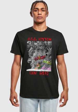 T-shirt noir avec un design graphique d'un visage sculpté agrémenté d'éléments de graffiti aux couleurs vives et du texte "TOUS LES YEUX SUR MOI".