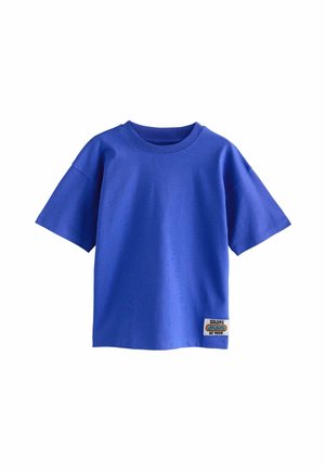 Blaues Baumwoll-T-Shirt mit kurzen Ärmeln, Rundhalsausschnitt und quadratischer Form; verfügt über ein Patch-Logo unten links. Weiche Textur.