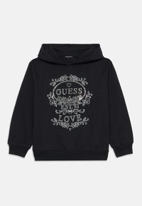 Svart hettegenser med snøring, med sølvfarget blomstertrykk som sier "GUESS EST. 81 LOVE" på forsiden. Mykt materiale.