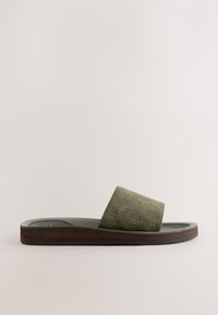 Sandale slide avec bride en suède vert olive perforée, semelle intérieure noire moulée et semelle épaisse marron, vue de profil latéral.