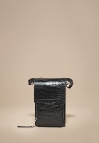 Sort lædertaske med krokodillemønster, med klaplukning, lynlåsdetalje og justerbar rem. Har en blank finish og præget logo.