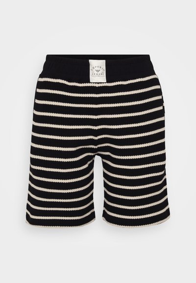 Black and cream striped shorts with a ribbed texture and elastic waistband. Features a branded tag at the back.