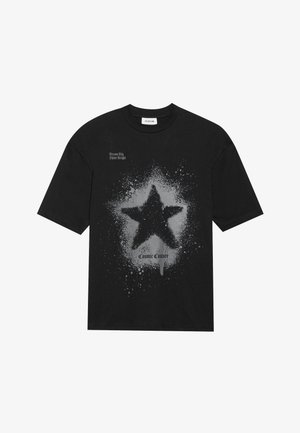 Črna bombažna majica s poudarjeno sivo zvezdo z močnim razlitjem. Napis "Sanjaraj veliko, zasijaj svetlo" nad in "Kozmična moda" spodaj.