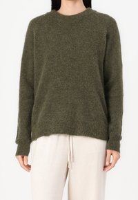 Maglione verde oliva in morbido maglione, con collo rotondo, maniche lunghe e una vestibilità leggermente ampia, con polsini e orlo a costine.
