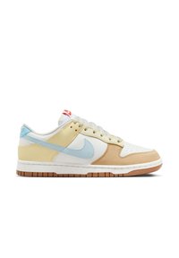 Zapatillas Nike Dunk Low que presentan una combinación de materiales de cuero y textil en blanco, amarillo, beige y azul claro, con una entresuela moteada y una suela de goma.