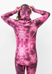 Sweat à capuche à manches longues, en tissu tie-dye avec des nuances de rose et de violet, doté d'ouvertures pour les pouces et d'une coupe ajustée.