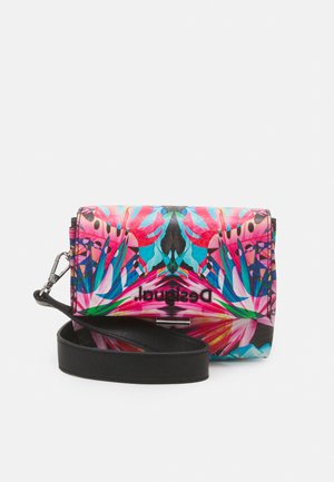 Sac bandoulière coloré avec des motifs floraux audacieux en rose, bleu et vert et une bandoulière en cuir noir amovible sur fond blanc.